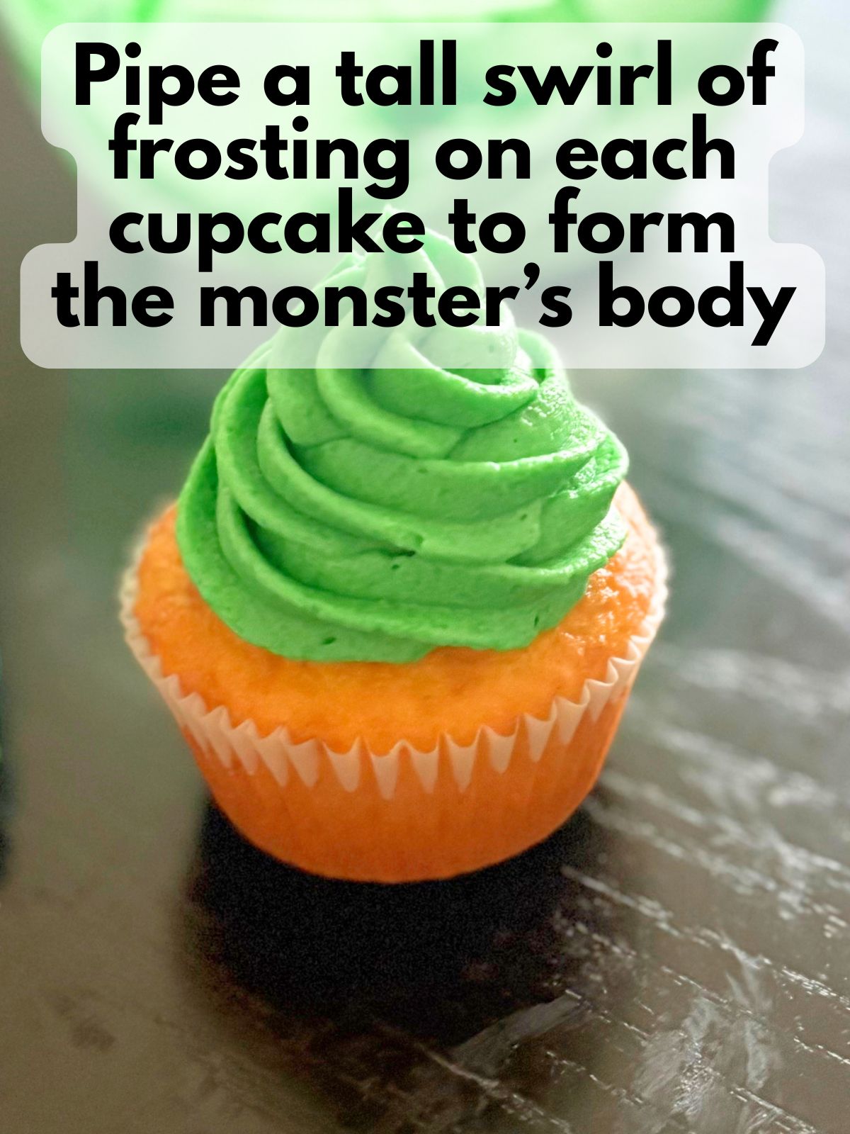 a tall swirl of green buttercream frosting on top of a cupcake