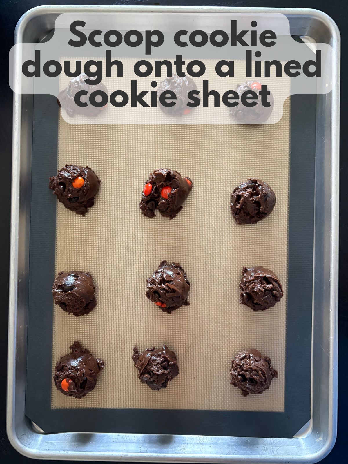 Halloween cake mix cookie dough scooped onto a lined baking sheet