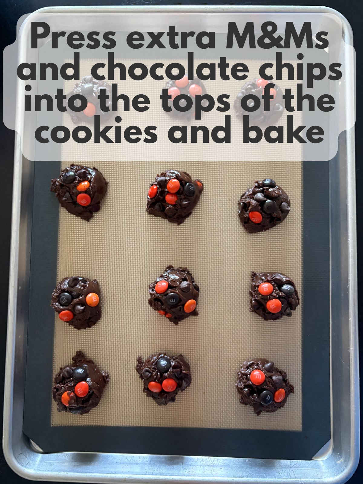 extra M&Ms and chocolate chips pressed into the outside of unbaked cookies