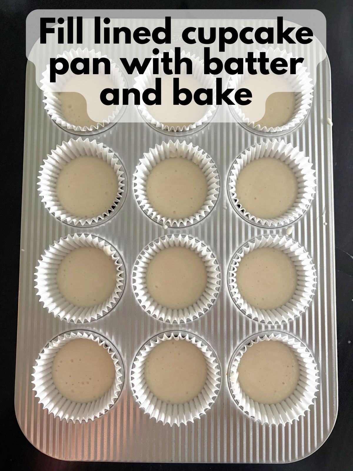 white cake batter in a lined cupcake pan