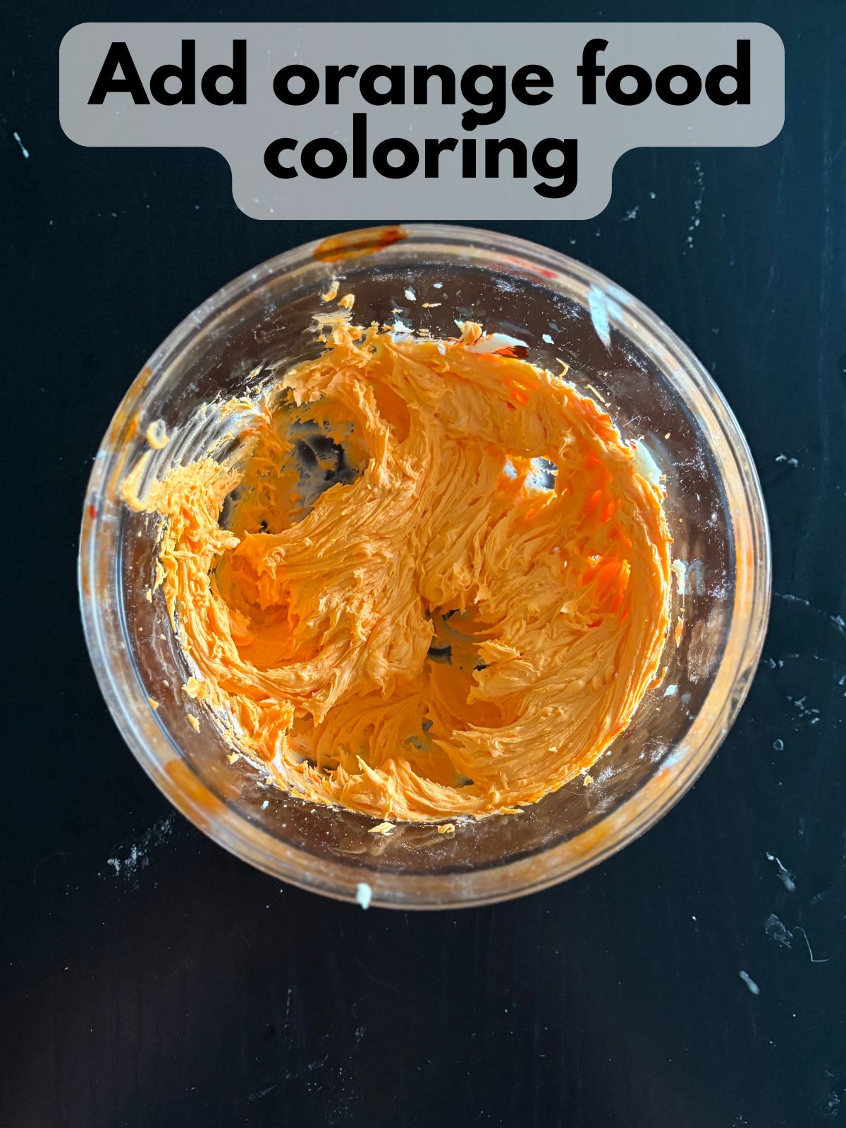 orange buttercream frosting in a bowl