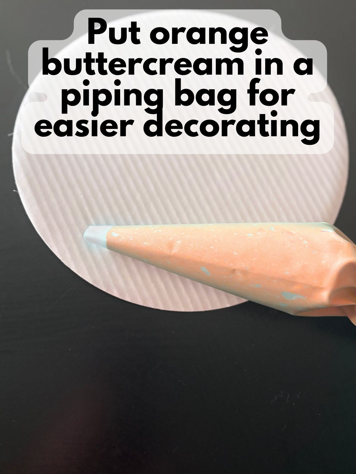 orange buttercream frosting in a piping bag with the tip cut off