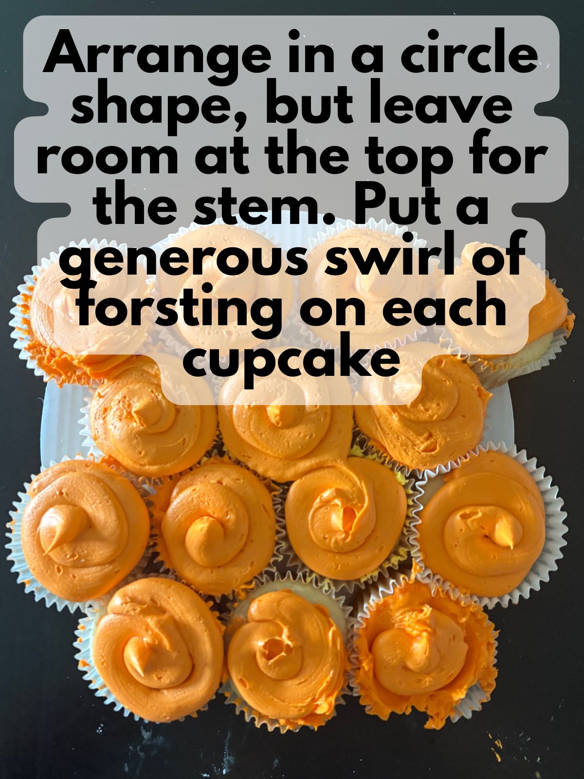 orange frosting swirled on top of each cupcake in a cupcake cake