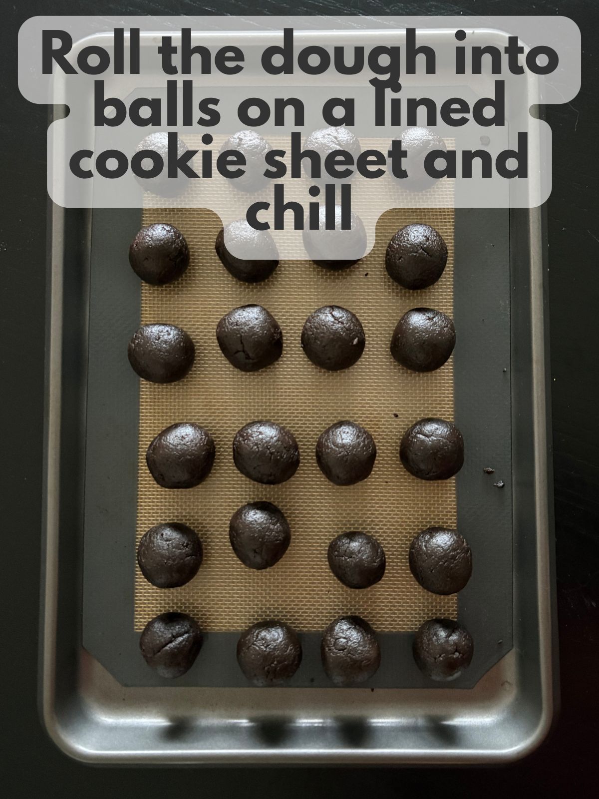 oreo dough rolled into balls on a lined cookie sheet