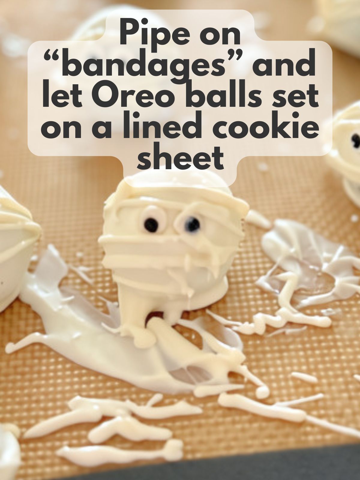 mummy oreo ball setting on a lined cookie sheet