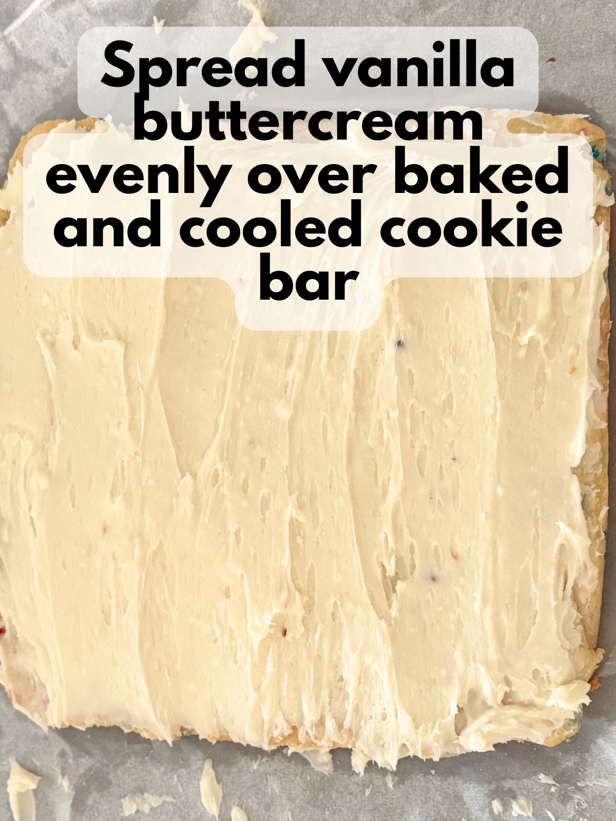 vanilla buttercream spread on top of baked cookie bars