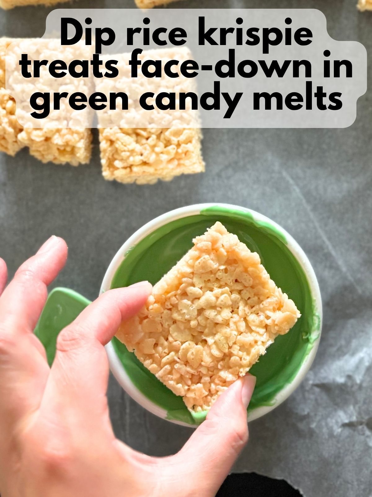 a rice krispie treat being dipped in melted green candy melts