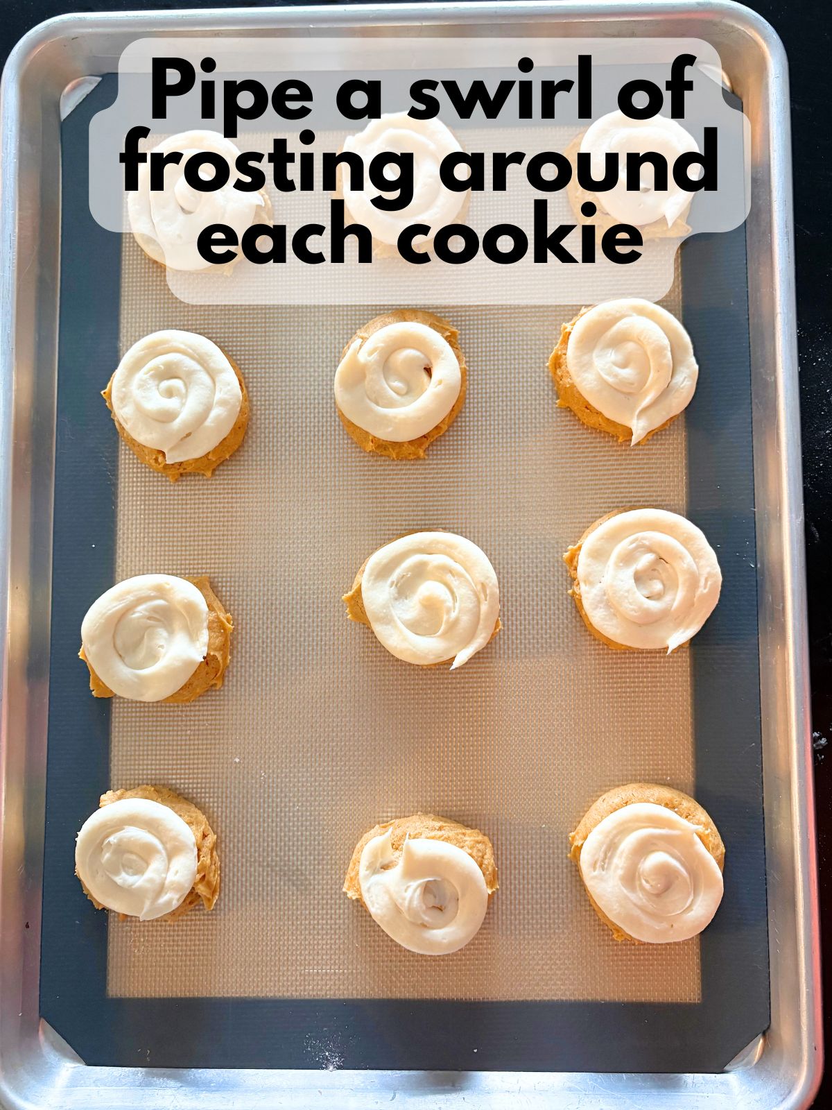 frosting piped on top of baked and cooled pumpkin cookies