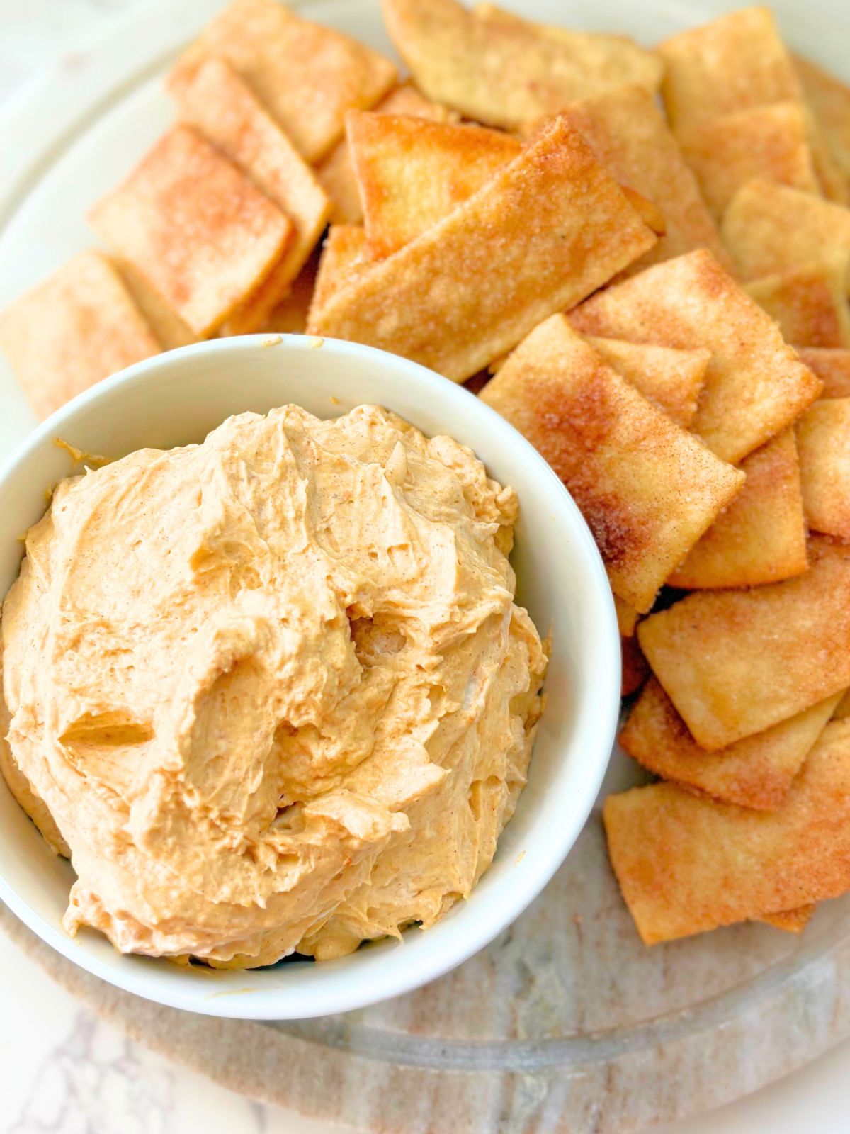 pumpkin pie dip in a bowl next to a pile of pumpkin pie dippers