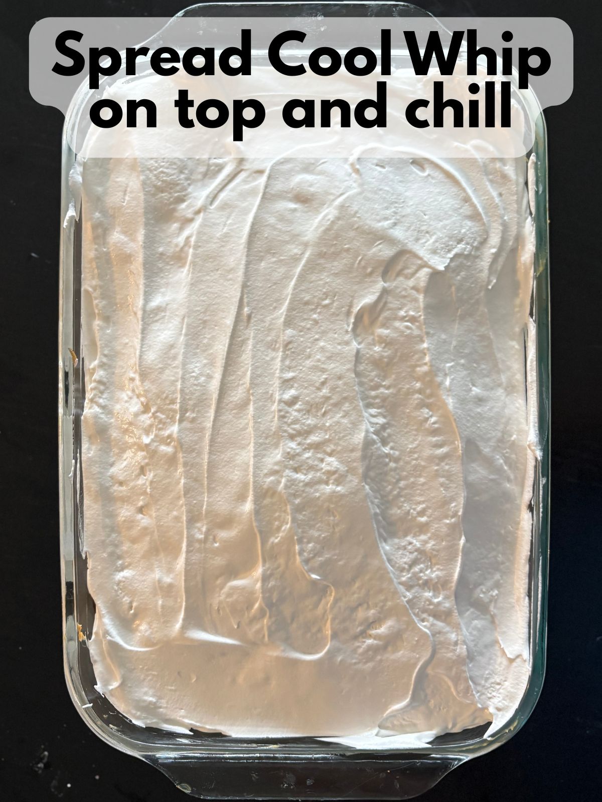 cool whip spread over the top of the poke cake