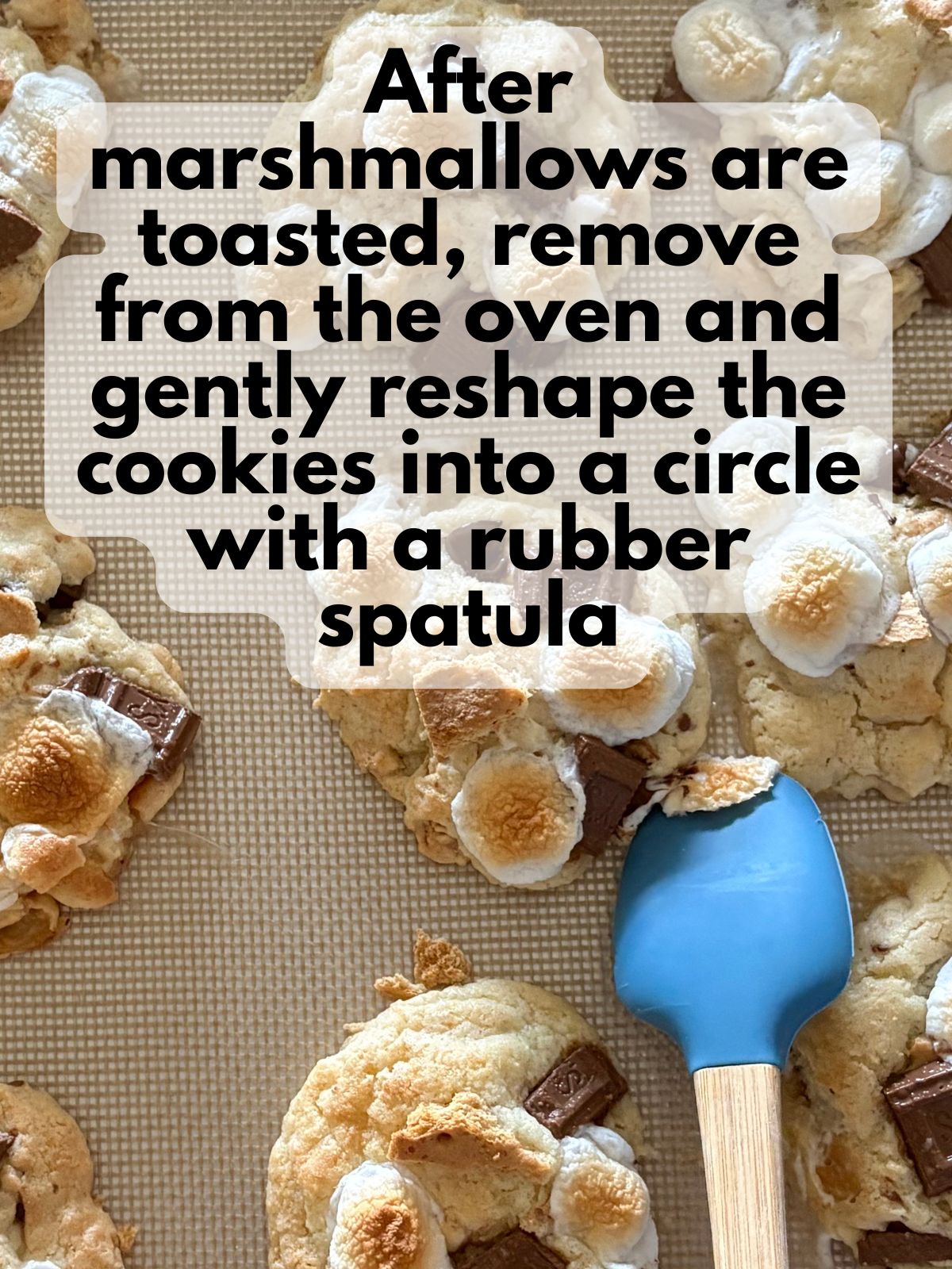 a rubber spatula gently pushing a smores cookie back into a circle shape