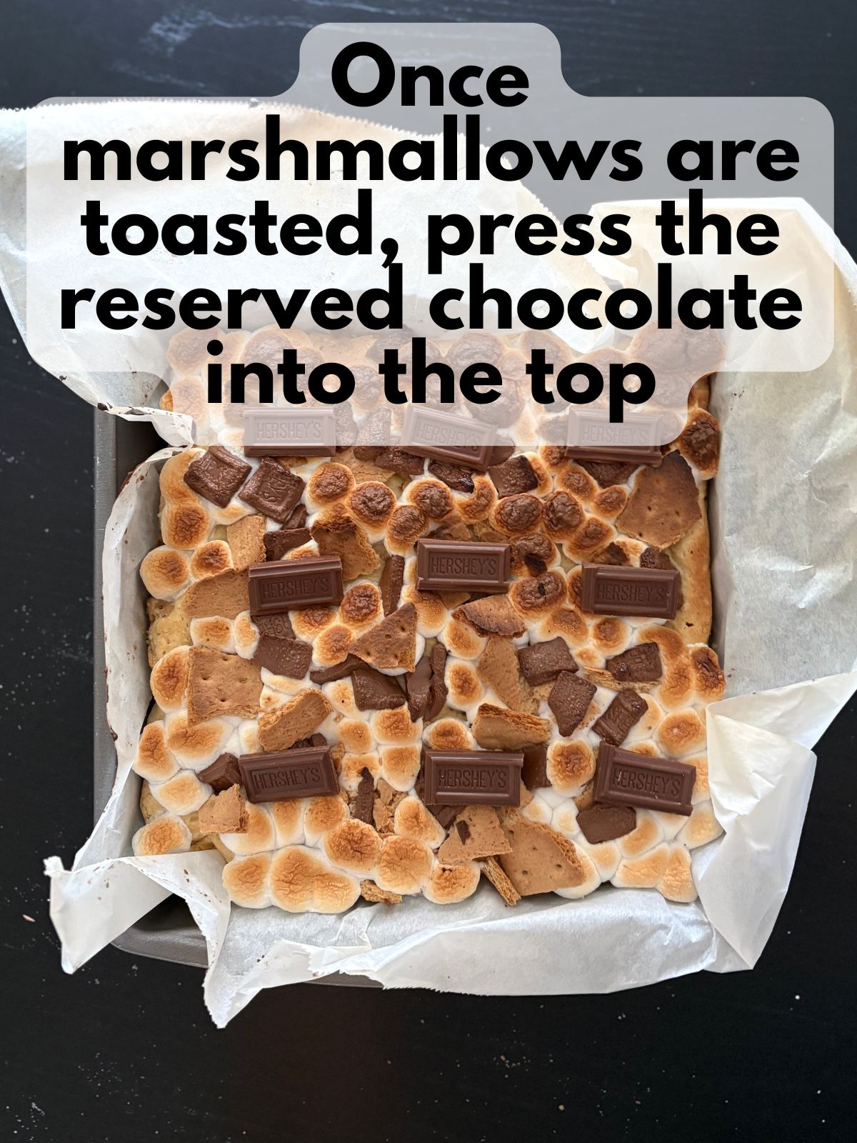Hershey's bar pieces pressed into the tops of s'mores bars
