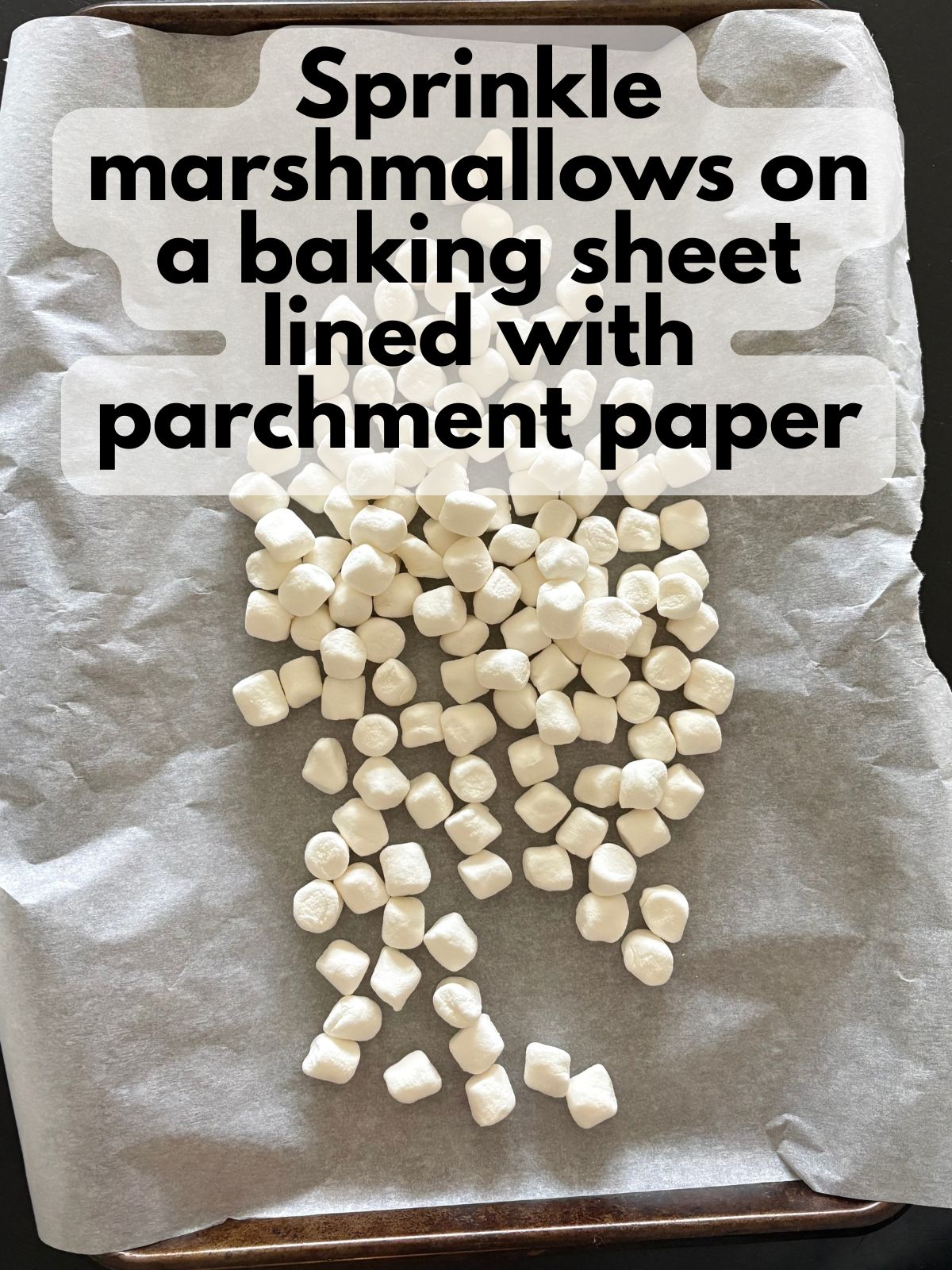 mini marshmallows on a baking sheet lined with parchment paper