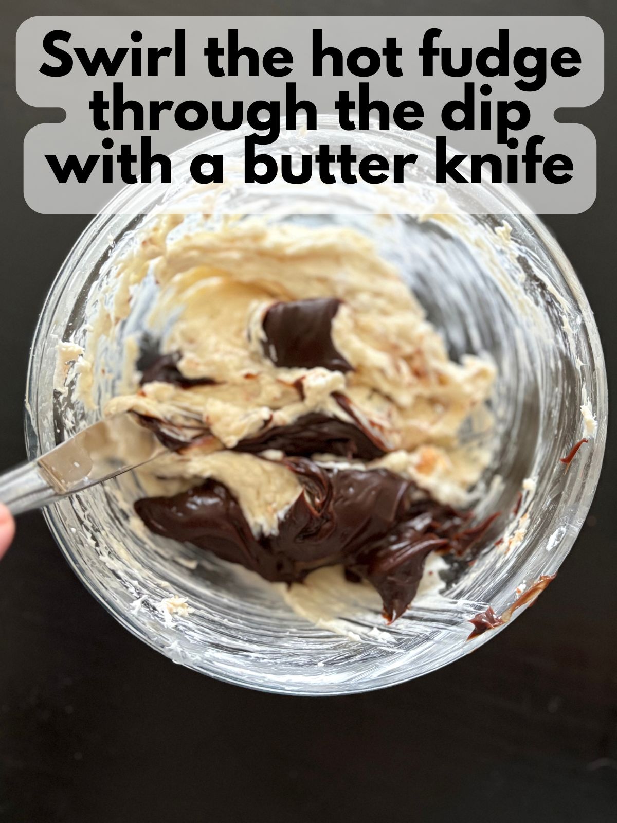 butter knife swirling hot fudge through marshmallow mixture