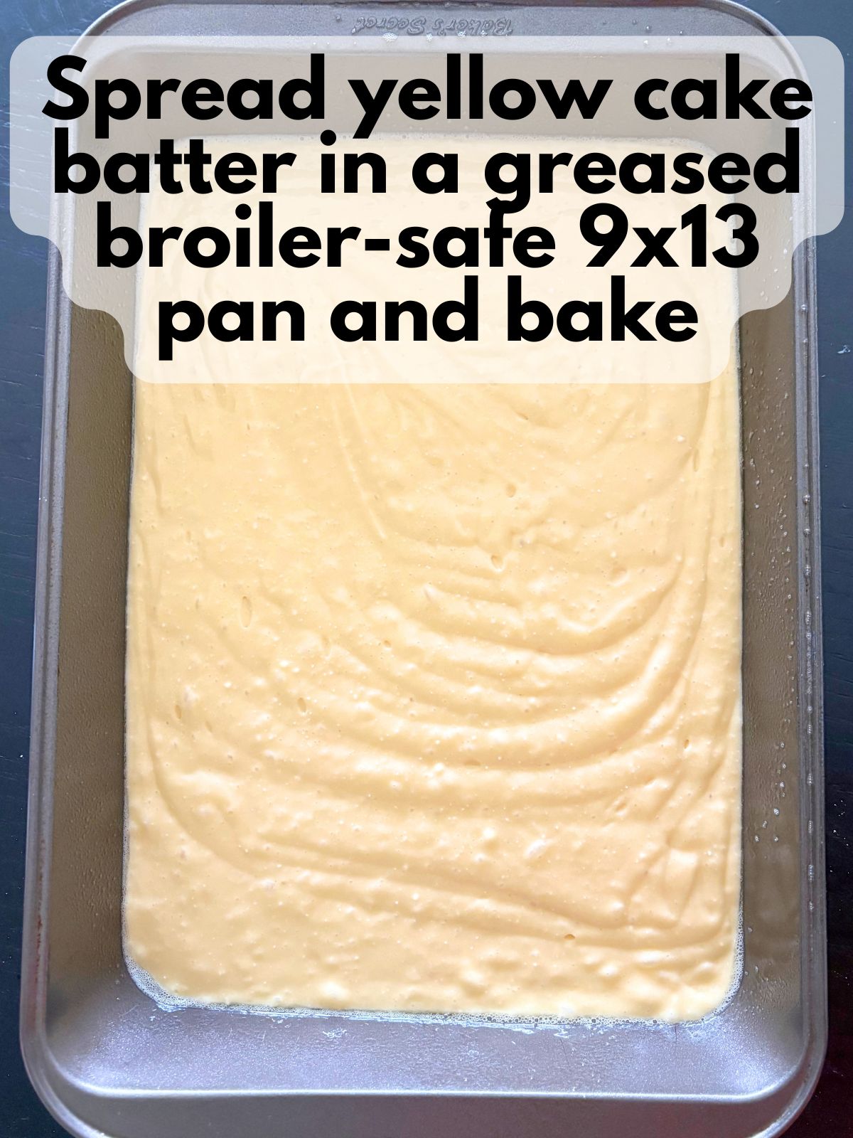 yellow cake batter in a metal 9x13 baking pan