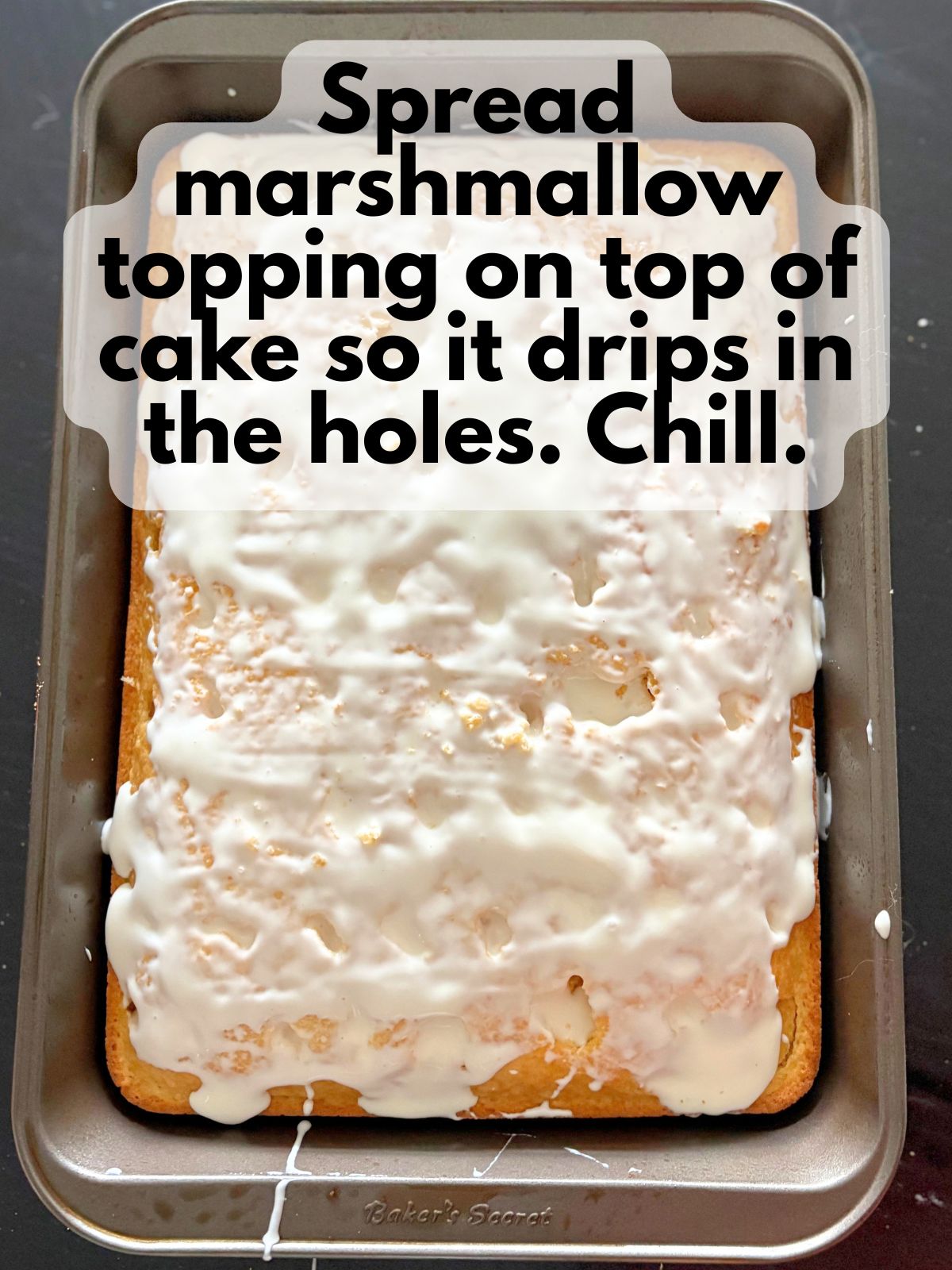 marshmallow topping spread over a cake poked with holes