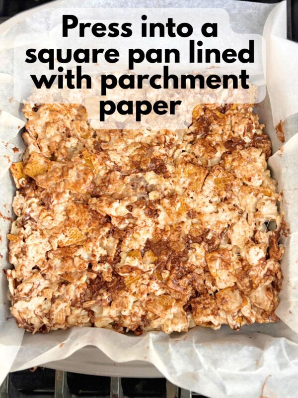 s'mores rice krispie treats pressed into a square pan lined with parchment paper