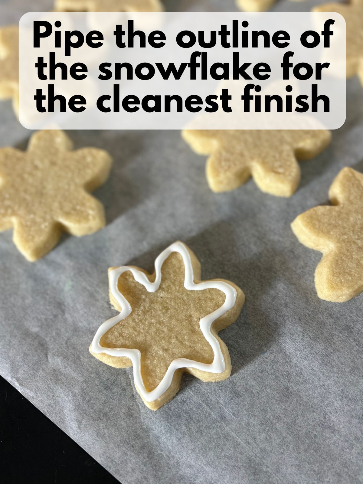 royal icing outlining a baked snowflake cookie