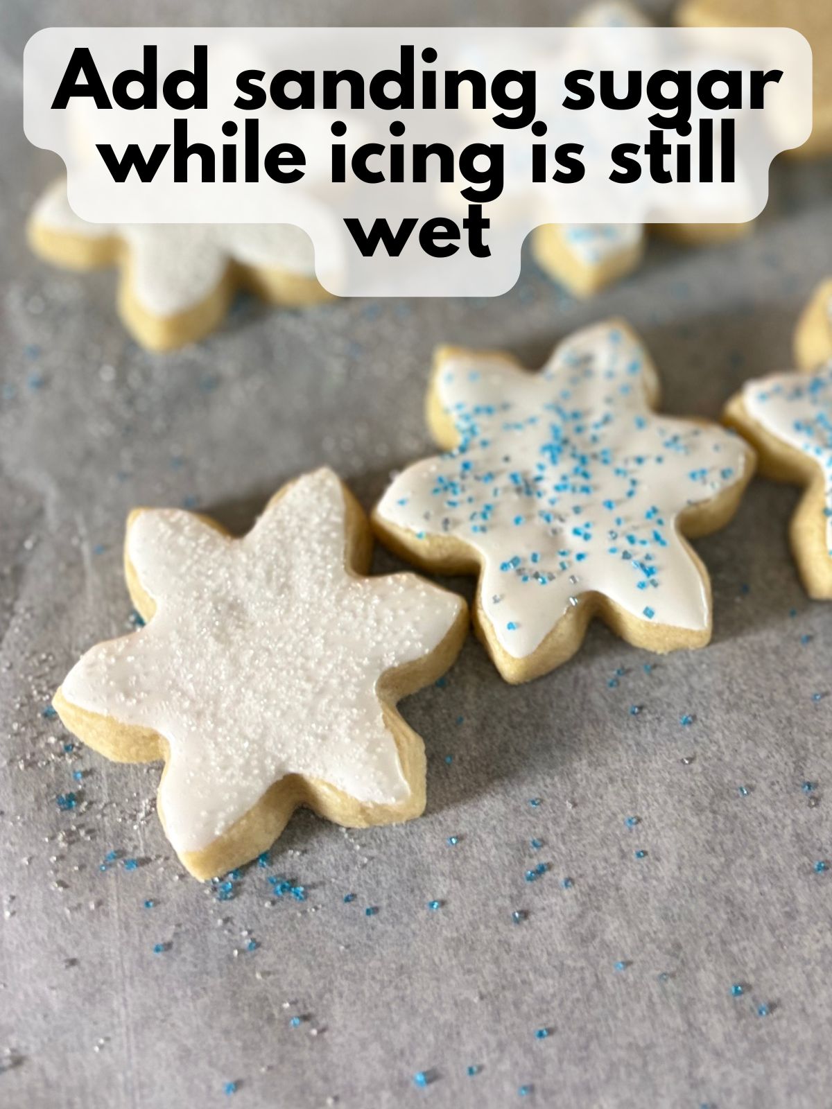 sanding sugar on top of iced snowflake cookies